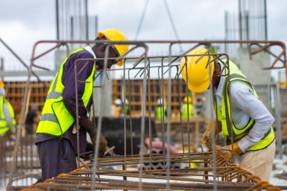 Trabajadores con casco y chaleco en una obra